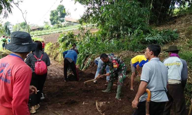 Babinsa Desa Sukawangi, Serka Ateng bersama masyarakat tengah membersihkan jalan lingkungan Dusun Cikaramas RW 04 yang penuh dengan tanah akibat hujan, Sabtu (31/10). (foto: istimewa)