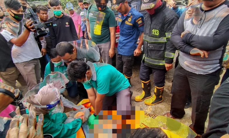 Petugas medis mengecek korban yang meninggal di dalam sumur usai dievakuasi petugas BPBD Sumedang dan lainnya, Sabtu (21/11). (foto: fajarnusantara.com)