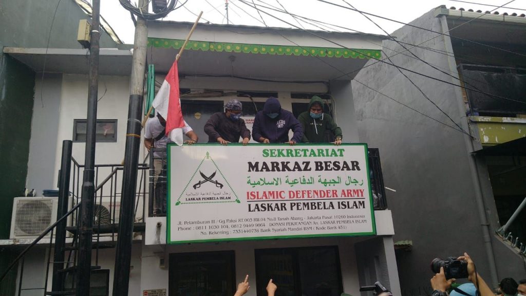 Sejumlah petugas terlihat tengah menurunkan papan sekretariat Markas FPI di Petamburan III, Jakarta Pusat, Rabu (30/12) sore. (Foto: Pikiran Rakyat)