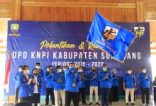 Ketua DPD KNPI Sumedang, Ekky Ahmad Muzaki Ramdhani, mengibarkan bendera KNPI di acara pelantikan pengurus KNPI Sumedang periode 2019-2022