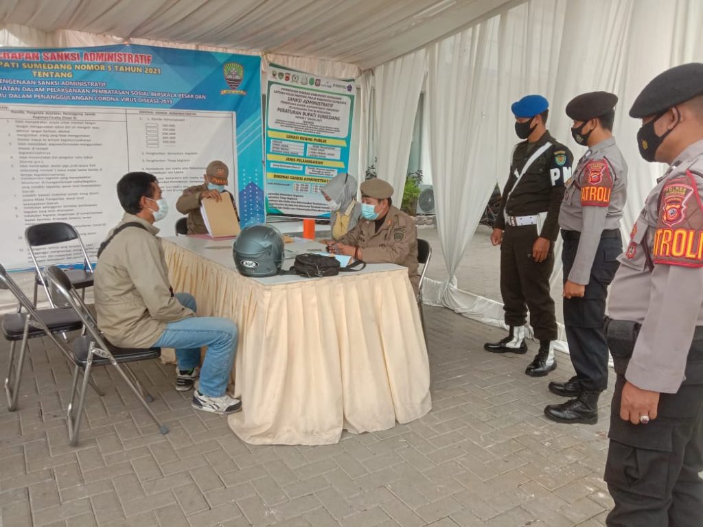 Sejumlah petugas gabungan Satgas Penanganan Covid-19 tengah mendata warga yang diduga melanggar prokes saat beraktivitas. (Foto: Humas Pemkab Sumedang)