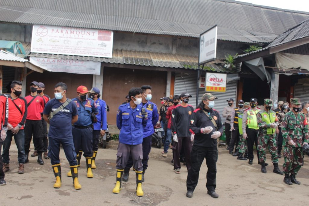 Petugas gabungan menggelar apel sebelum melakukan penyemprotan disinfektan dan operasi bersih di lokasi Pasar Tradisional Tanjungsari Kabupaten Sumedang, Jumat (5/2/2021). (Foto: IST)