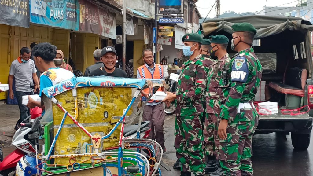Sejumlah prajurit Yonif Raider 301/PKS membagikan paket nasi untuk abang becak di seputaran Sumedang Kota. (Foto: Yonif Raider 301/PKS)