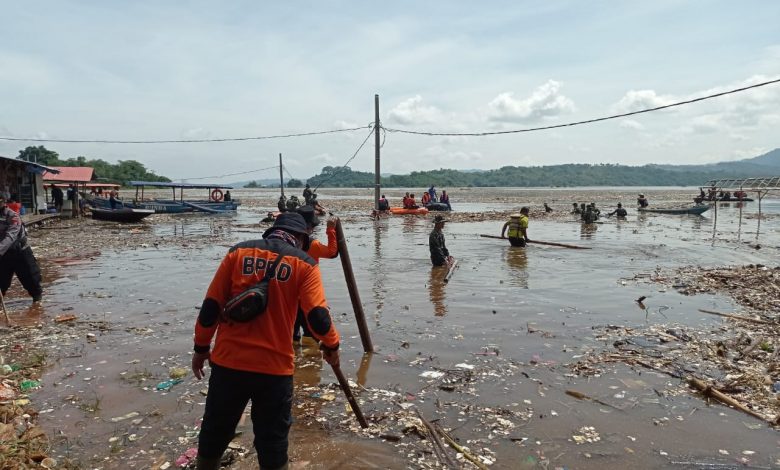 Sejumlah petugas terus berusaha membersihkan sampah di pesisir Bendungan Jatigede. (Foto: Humas Pemkab Sumedang)