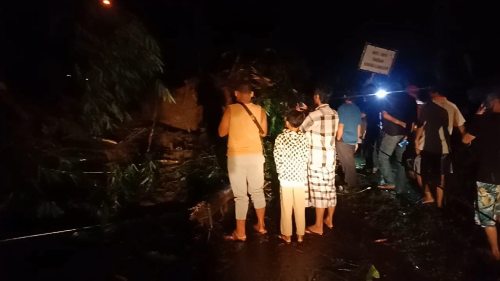 Sejumlah warga mleihat ke lokasi longsor yang menutup total Jalan Raya Conggeang-Buahdua, Kamis (25/3/2021) malam. (Foto: Fajarnusantara.com)