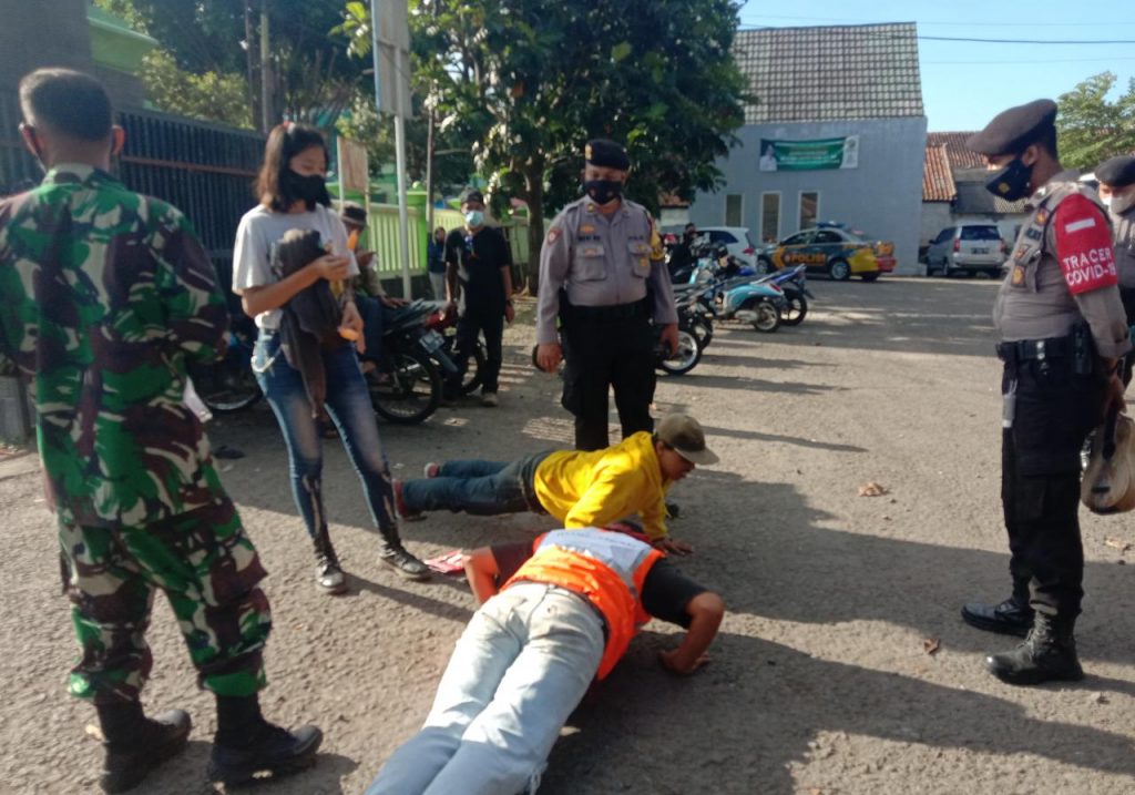 DISANGSI PUSH UP : Petugas operasi yustisi penerapan protokol kesehatan saat menyangsi dua anak jalanan karena tidak memakai masker