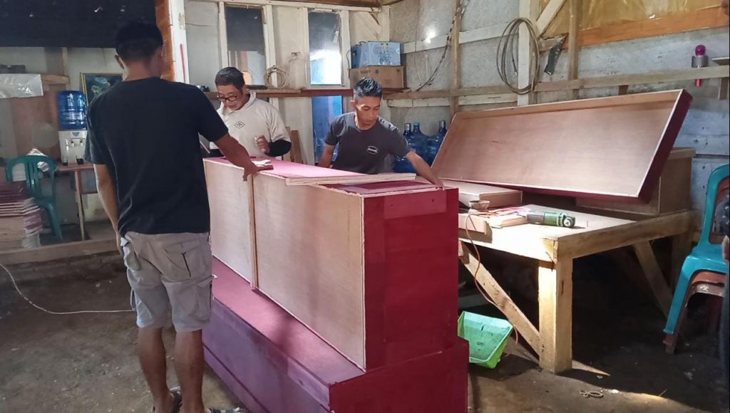 MEMBUAT PETI MATI : Tampak pekerja pembuat peti mati di Desa Cijambu Kecamatan Tanjungsari saat menyelesaikan orderan yang siap dikirim keberbagai wilayah.