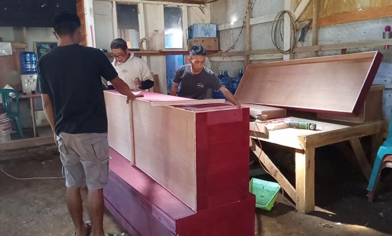 MEMBUAT PETI MATI : Tampak pekerja pembuat peti mati di Desa Cijambu Kecamatan Tanjungsari saat menyelesaikan orderan yang siap dikirim keberbagai wilayah.