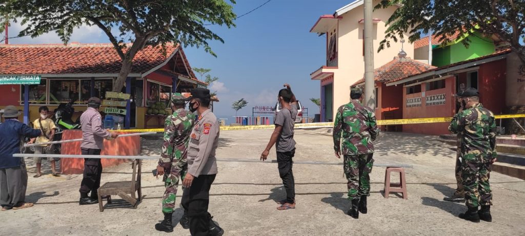 Petugas gabungan memasang garis polisi di kawasan Puncak Permata Jatigede karena masih kedapatan buka dan mengundang kerumunan wisatawan, Sabtu (4/7/2021). (Fajarnusantara.com)