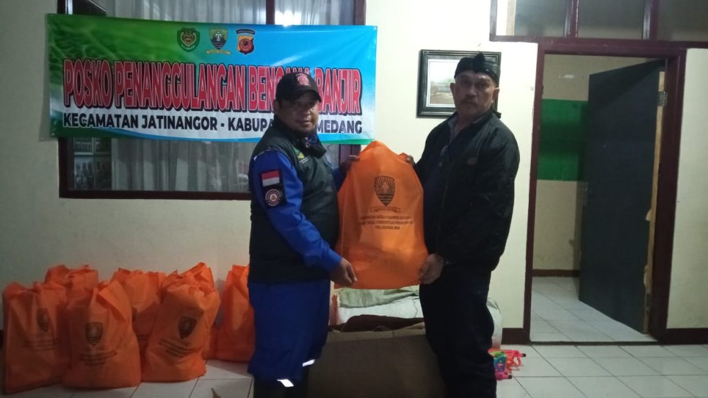 Photo : Anggota Tagana Kab Sumedang menyerahkan bantuan Logistik dan alat kebersihan