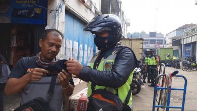 Babinsa Koramil 1004/Tanjungsari saat membagikan masker kepada warga yang kedapatan tidak memakai masker disaat PPKM Level 3