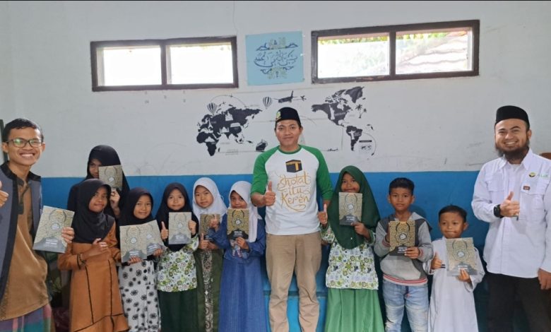KEPALA Bidang Kesehatan dan Sosial PC AMK Garut, Adi bersama Ketua PAC AMK Tarogong Kidul Asep Kotax foto bersama Guru dan Santri Madrasah Al Ihsaniyyah, pada acara pembagian Alquran gratis, Sabtu. Ist